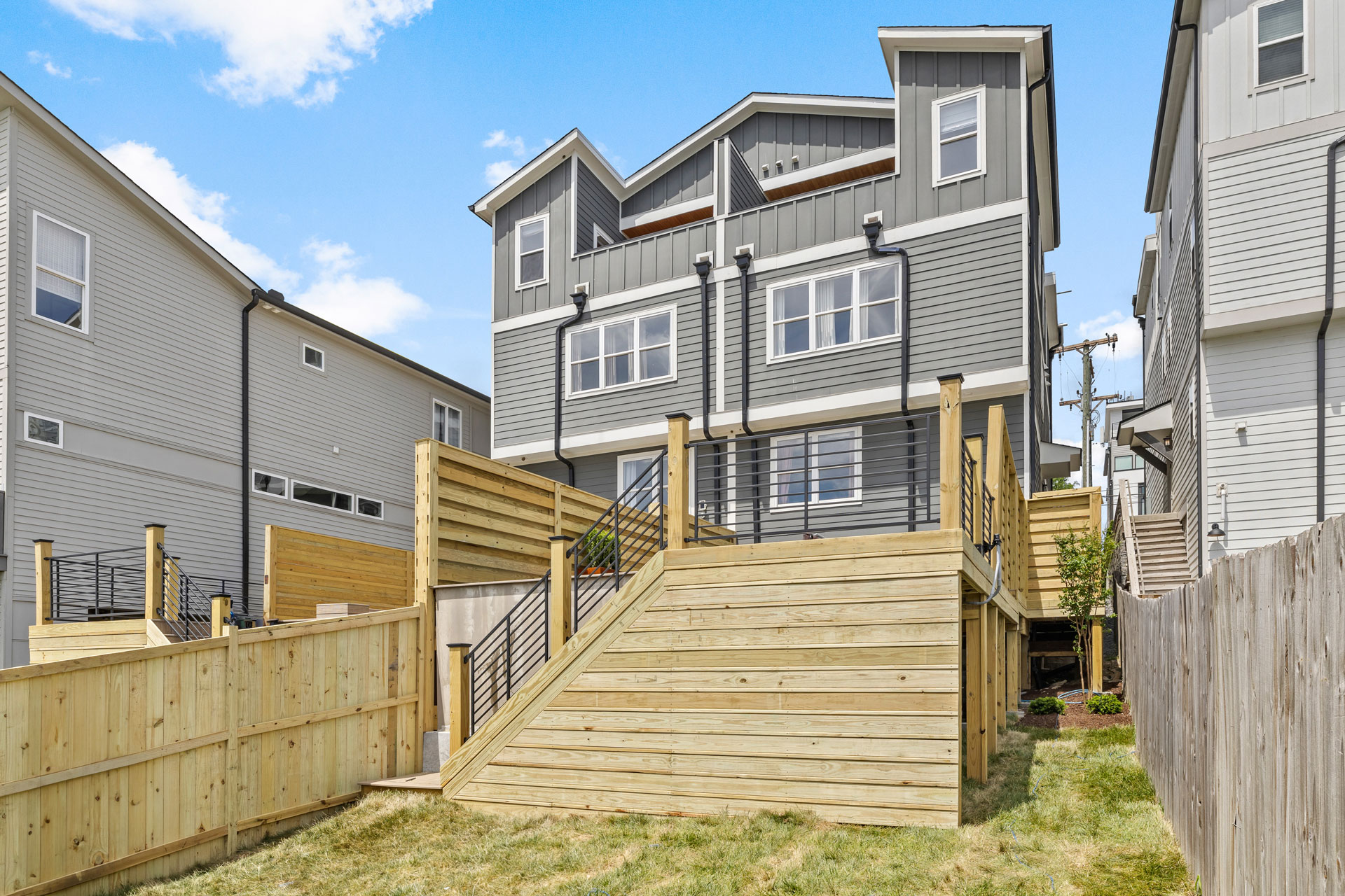 Close-up view of multi-level deck with metal stair railings, showcasing modern design elements and durable materials for outdoor living spaces.