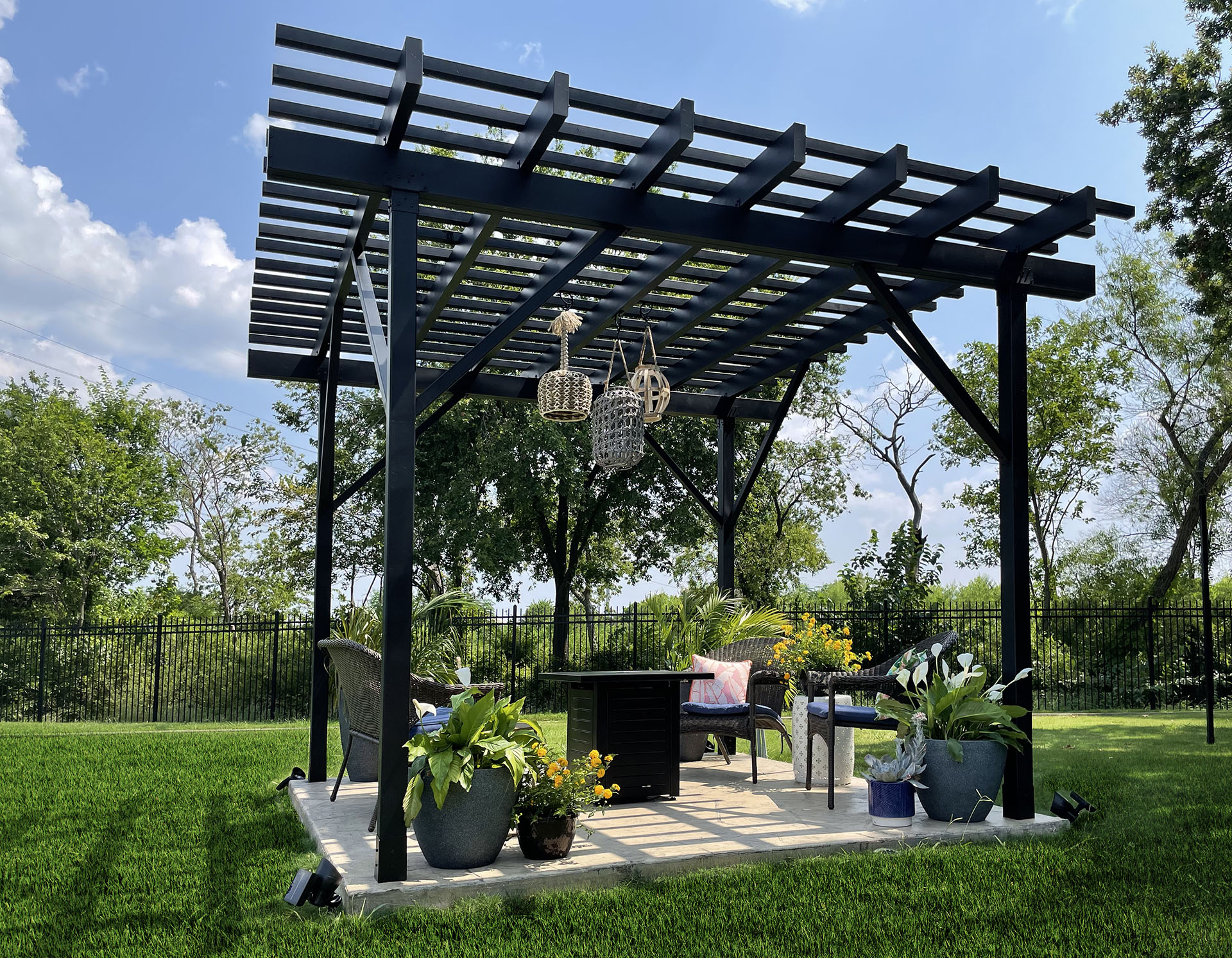 An outdoor area with a fire-resistant pergola, equipped with a grill and chairs, ideal for entertaining in the yard.