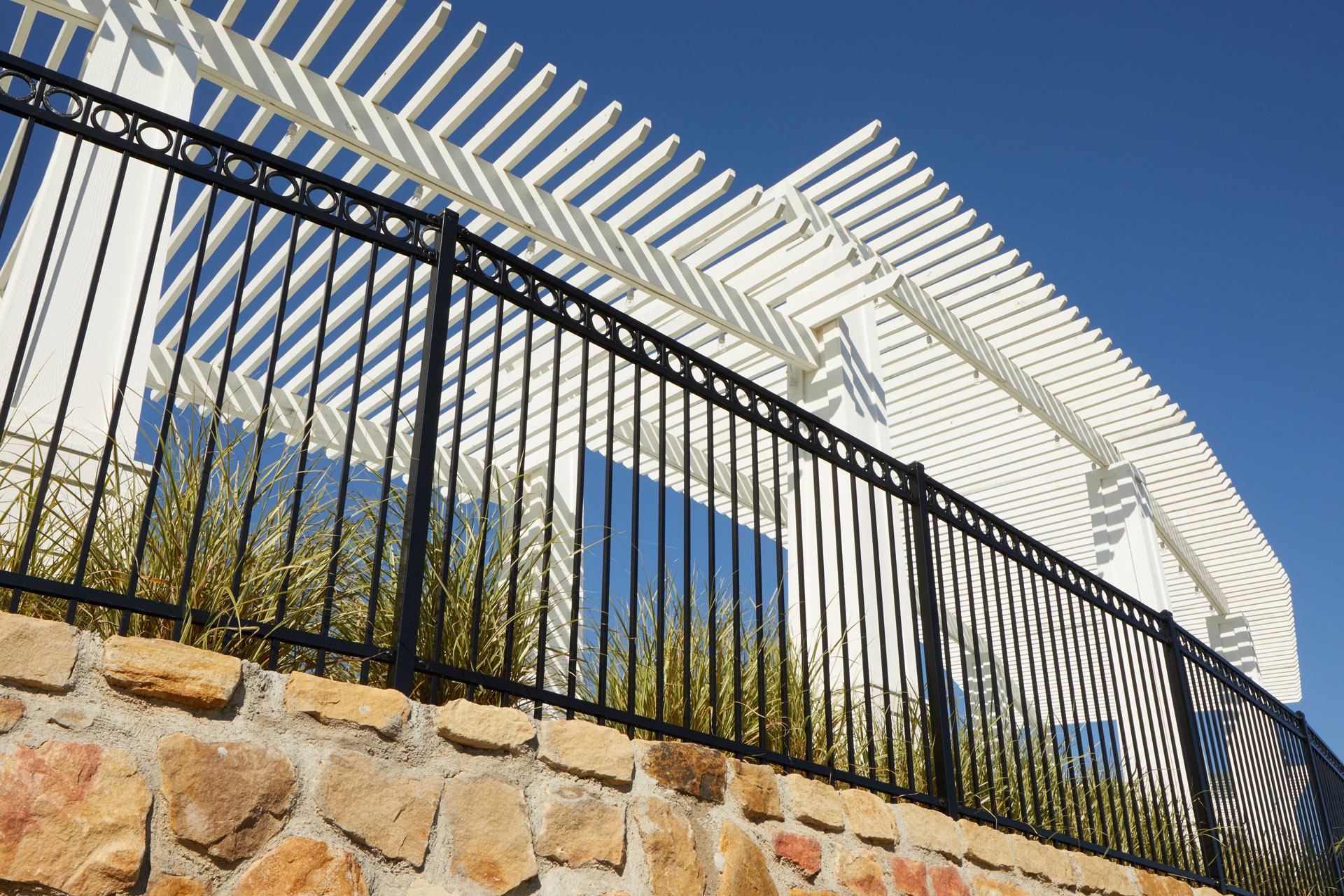 A modern white steel pergola paired with black steel fencing offers a stylish,fire-safe, and WUI-compliant outdoor living space.