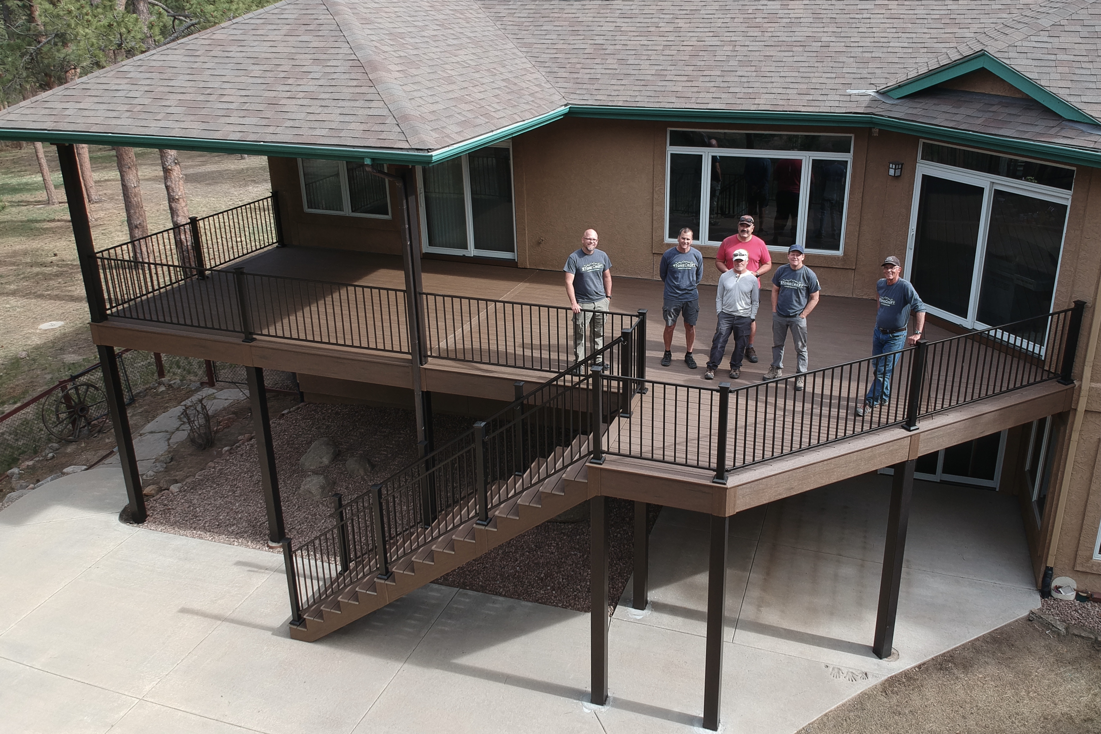 A completed steel-framed balcony showcasing modern design, durability, and fire safety, with builders standing on the outdoor structure.