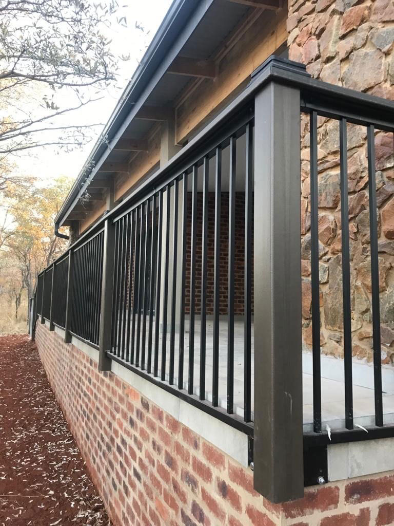 Close-up of aluminum railings mounted on a brick base. 