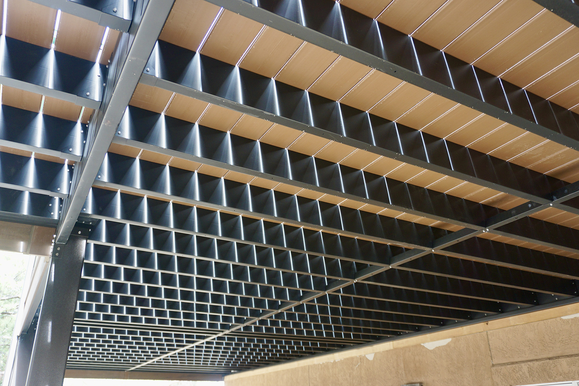 Underneath view of a steel deck frame with composite decking boards.