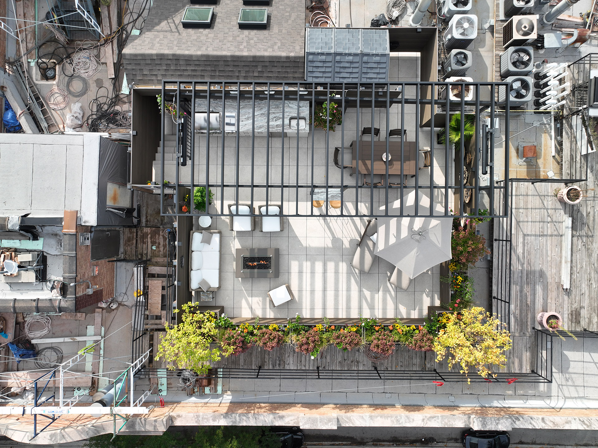 Aerial view of a spacious rooftop deck with a steel pergola.