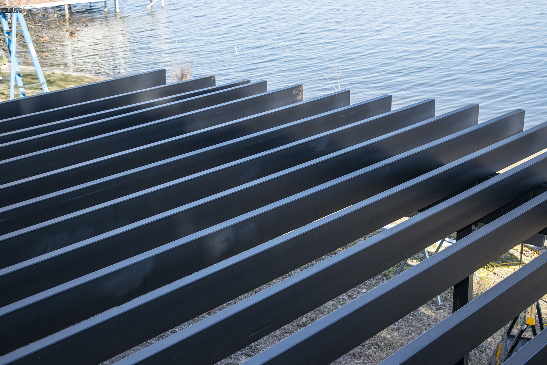 Steel deck framing next to a body of water.