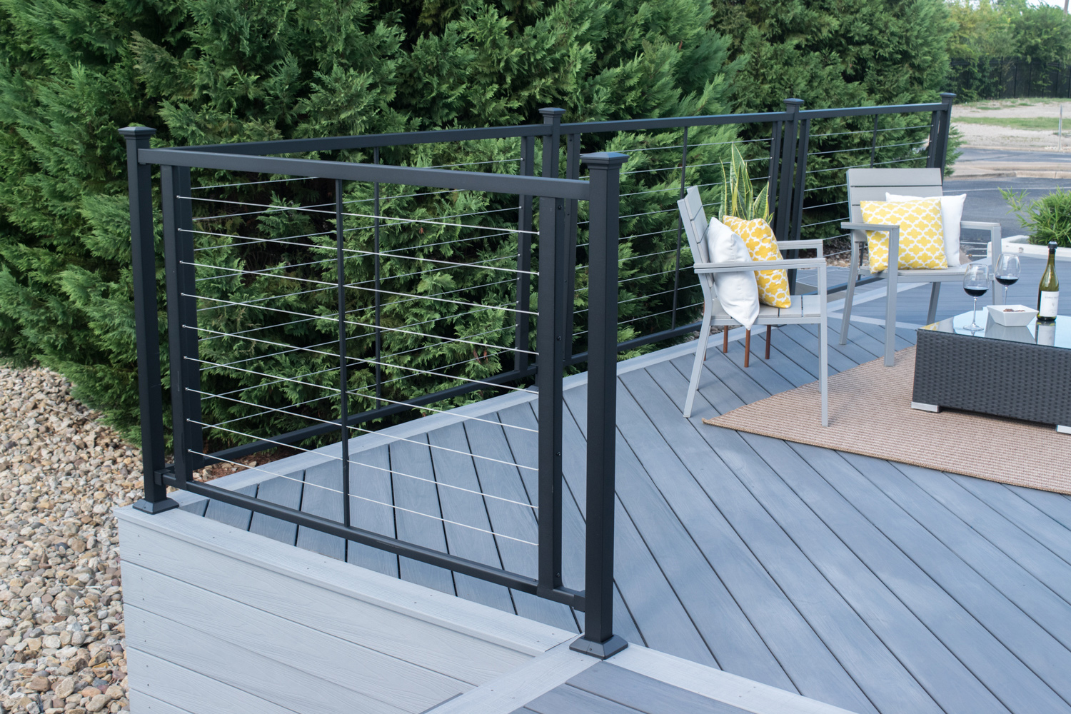 Cable deck railing on a grey back patio deck.