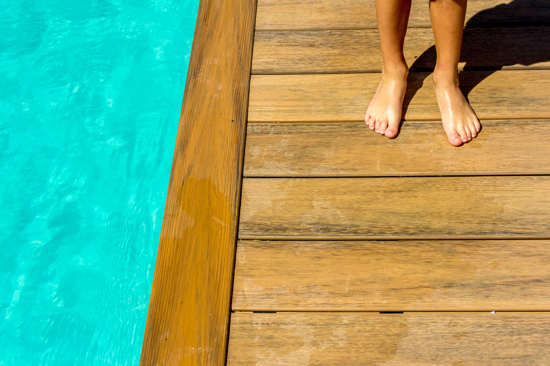 Wet feet standing poolside on composite decking