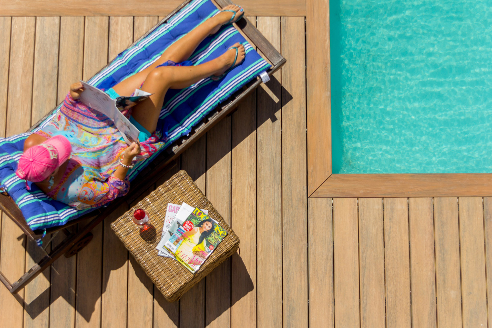Woman laying poolside on slip resistant composite deck.