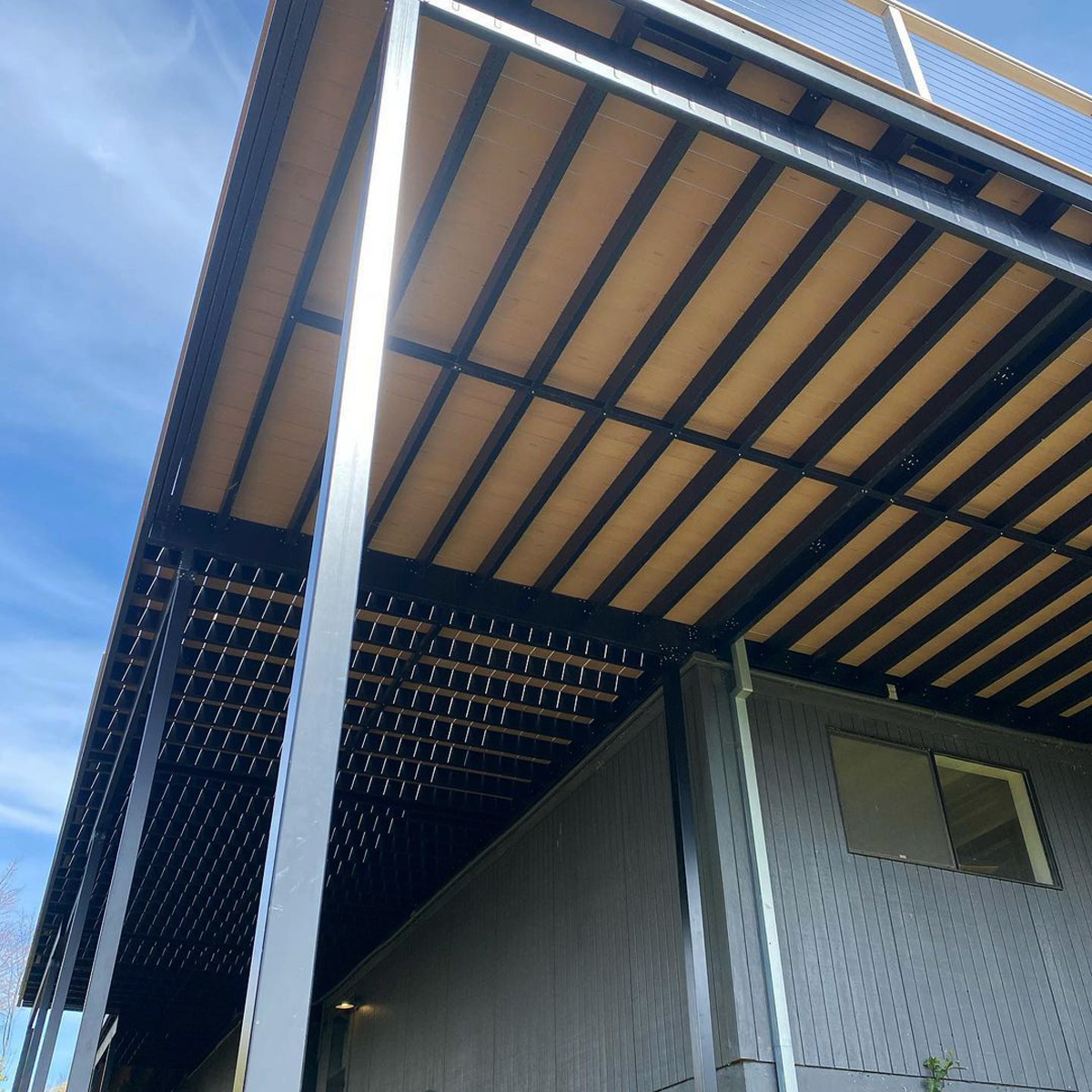 View from beneath a completed second story deck showing the steel framing and posts.