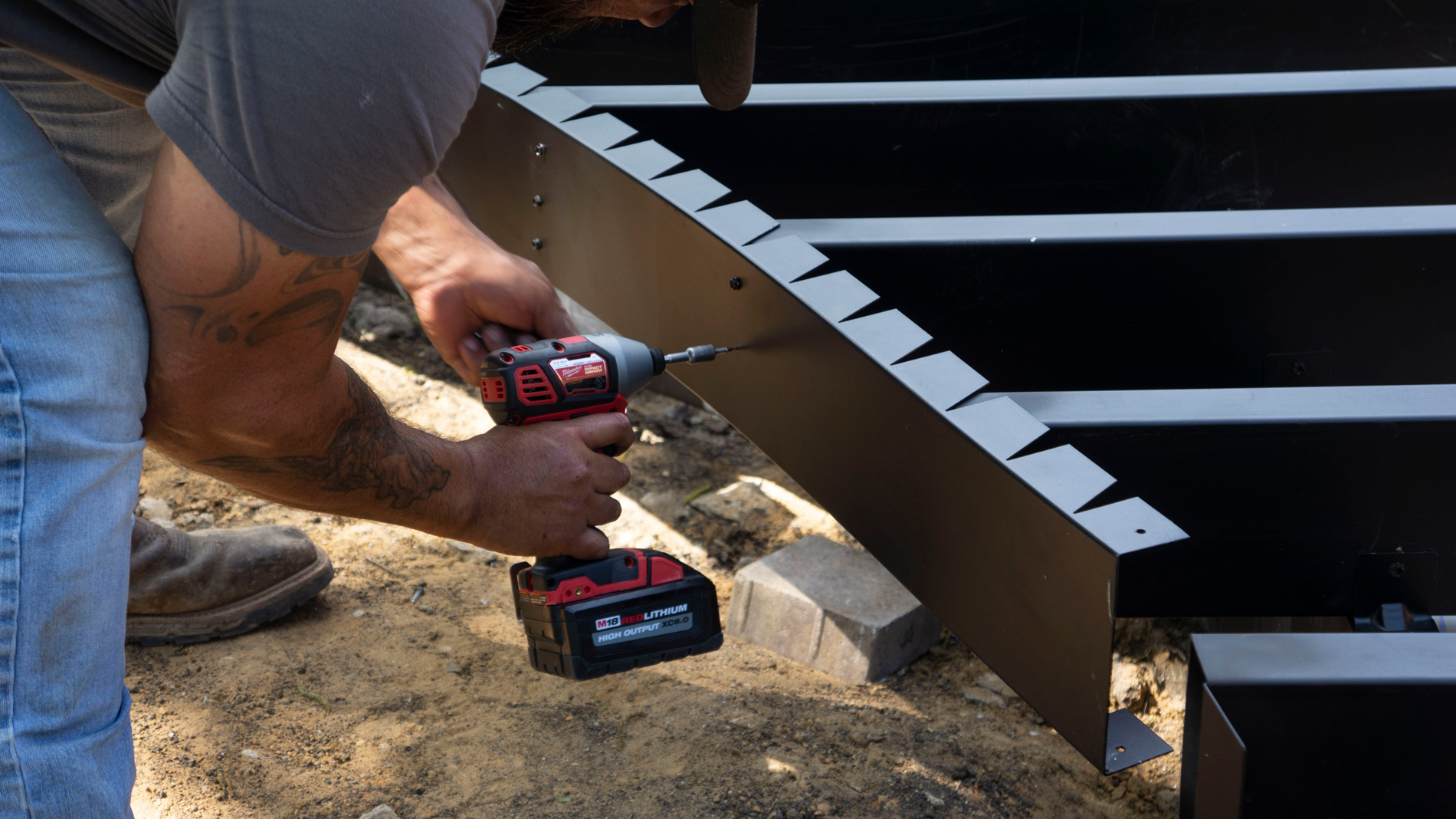 Man using a drill to put together the steel deck framing.