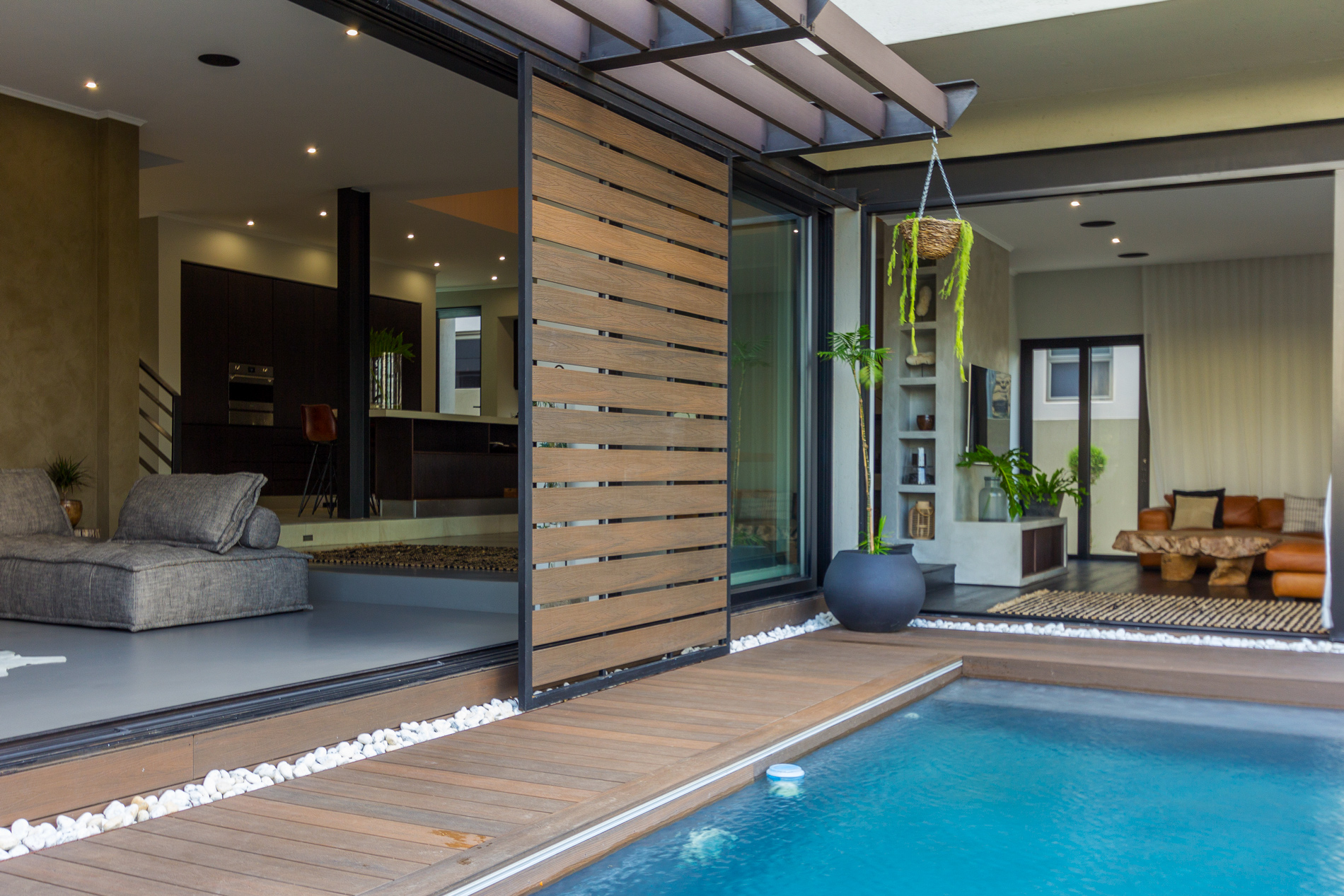 A sliding glass door with composite cladding is opened to connect indoor and outdoor living spaces. 