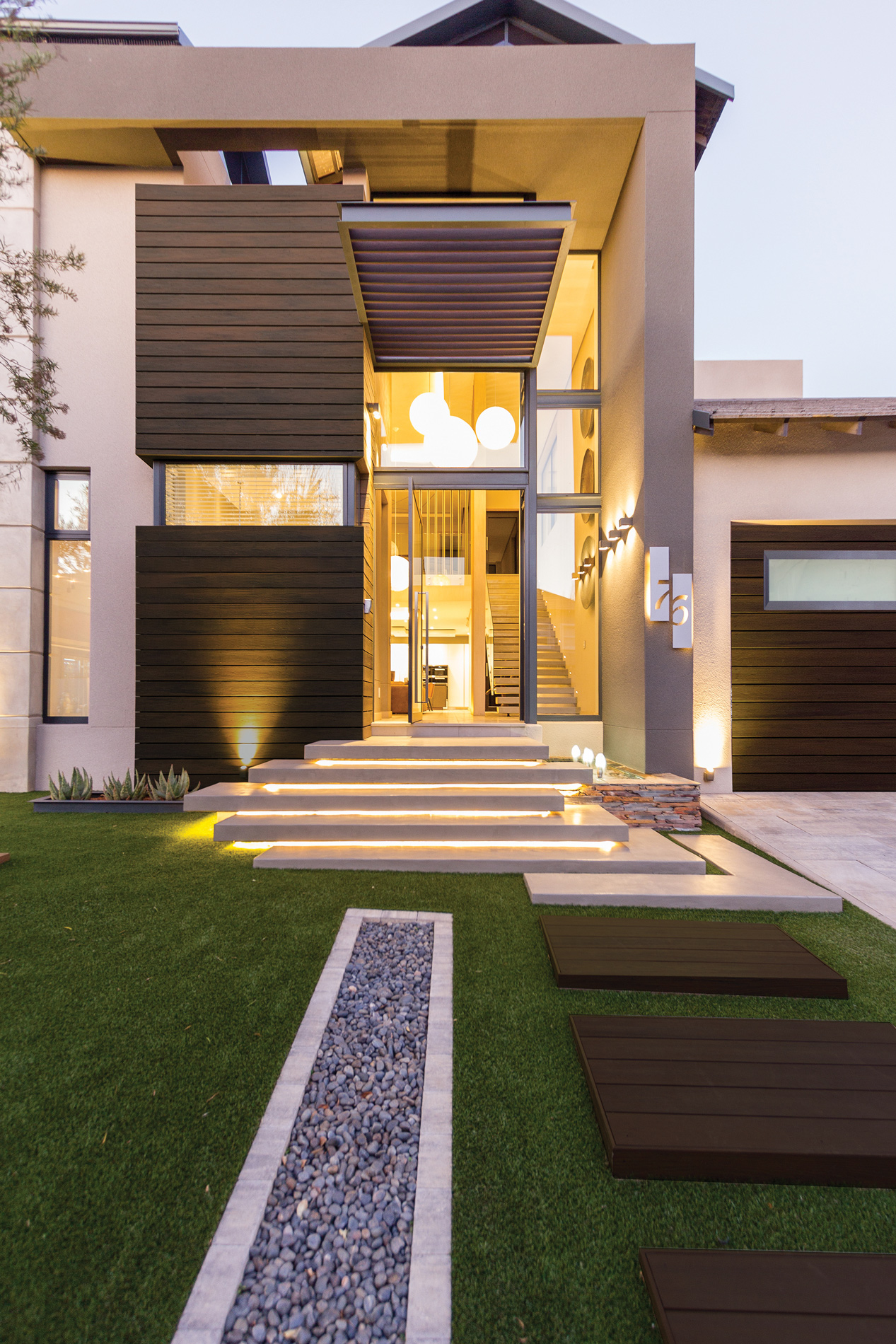 The front of a modern home that features composite cladding on the garage and to the left of the entry door. 