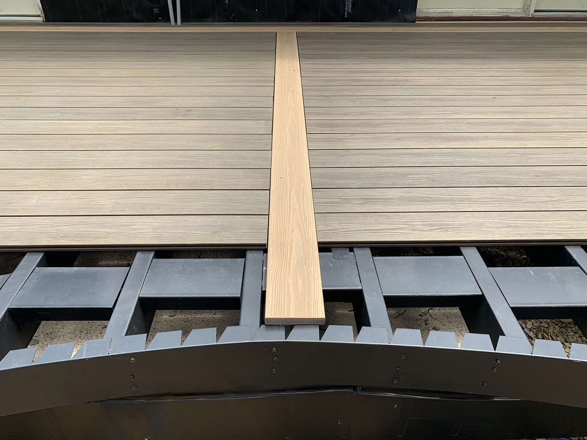 Curved deck frame with composite deck boards installed on the surface.