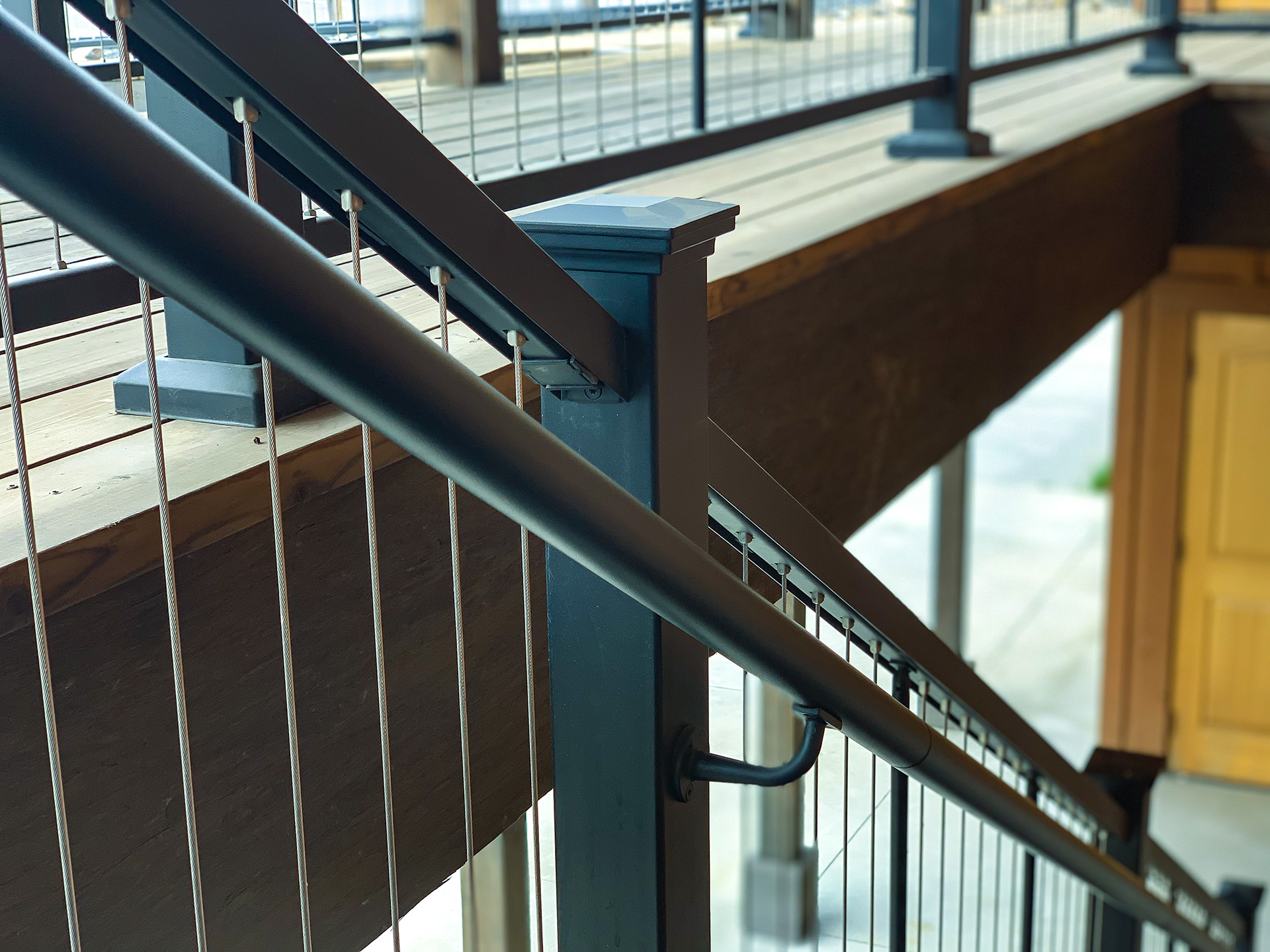 A close-up view of cable railing on an outdoor staircase, showcasing the design and durable materials used in the railing system.