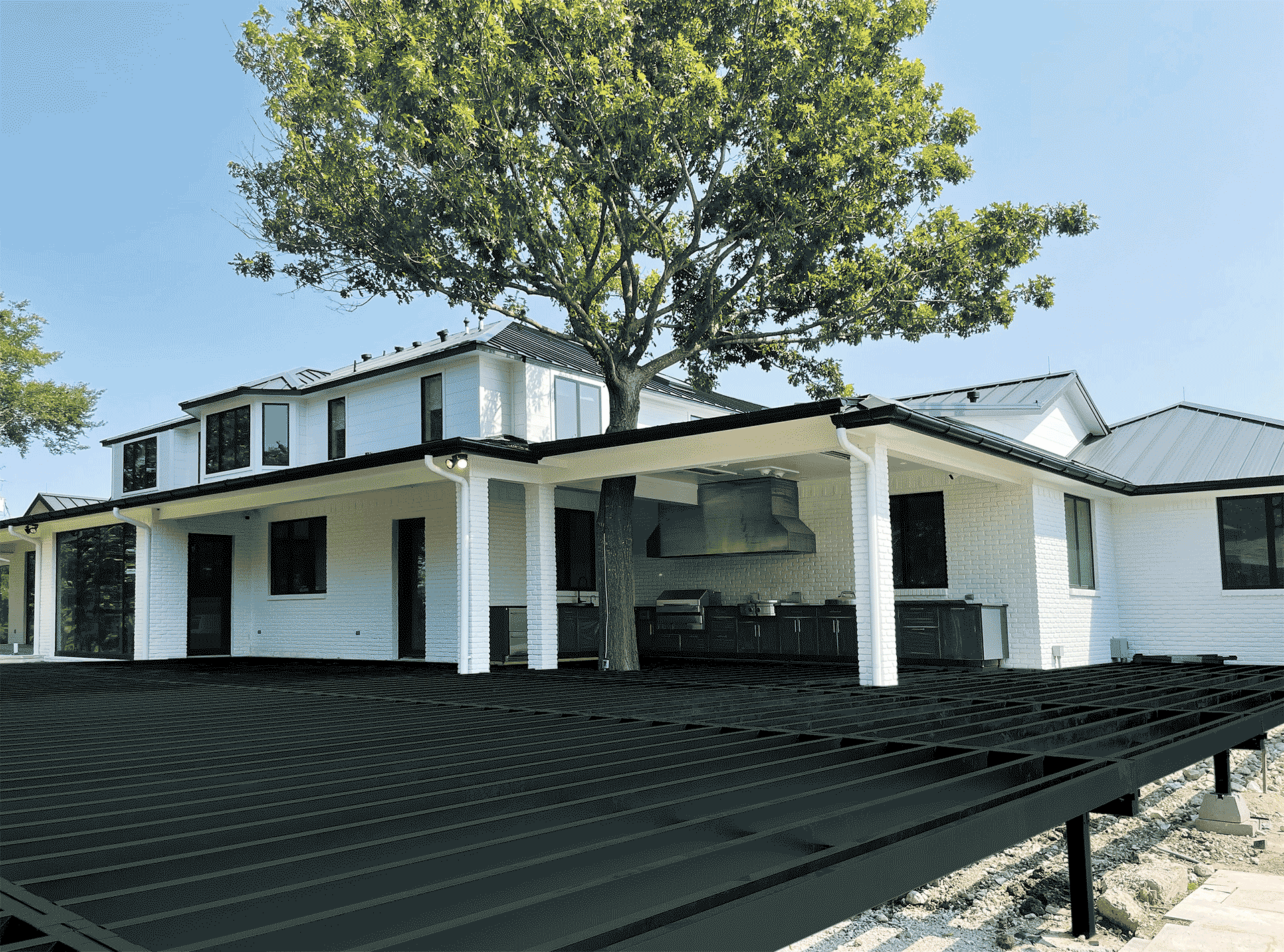 Steel deck framing attached to modern white home.