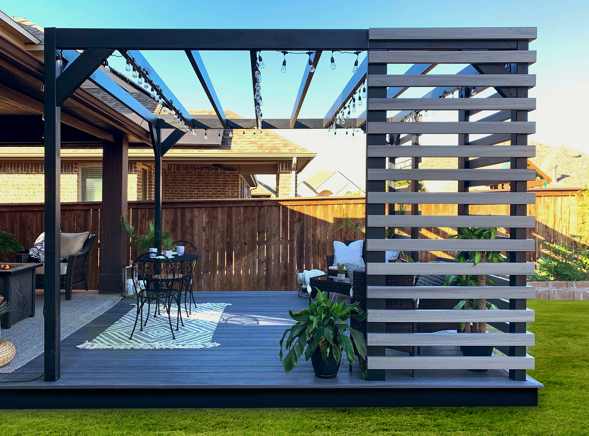 Steel pergola with privacy boards shelters ground level deck