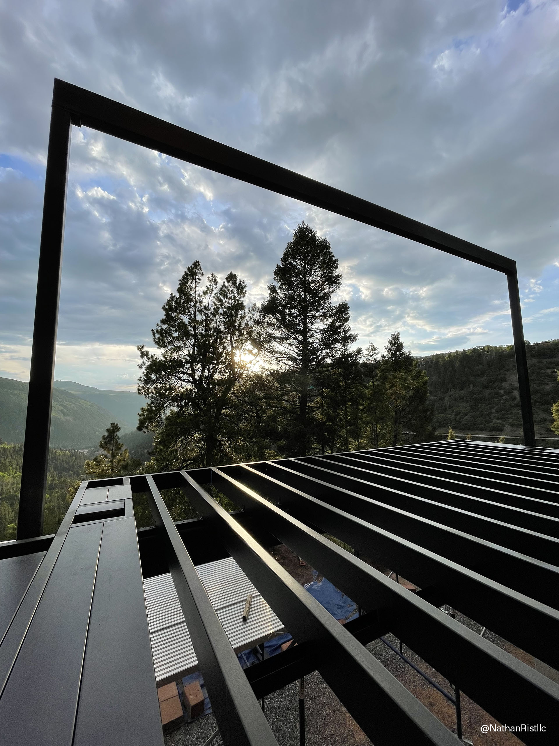 View from the top of a multi-level metal deck structure, showcasing surrounding landscape and distant horizon.